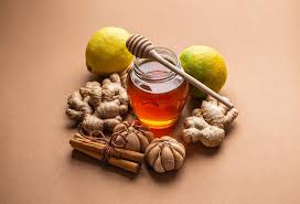 Display of honey jar, limes, ginger, garlic, and cinnamon - showcasing natural ingredients