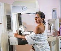 Mammograms procedure: Woman standing in front of the mammography machine.