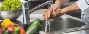 Person washing their hands - Essential step for food safety and hygiene.